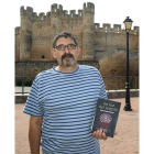 Mendoza sostiene su libro ante el castillo de Coyanza.