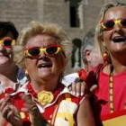 Mujeres sevillanas lucen gafas y blusas con los coleres de la bandera