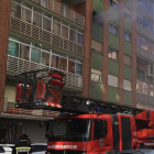 Las llamas asoman por la ventana de la vivienda incendiada en Fray Luis de León. DL