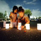Una mujer y su hija colocan una vela durante una vigilia por las víctimas.