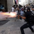 Un policía antidisturbios dispara gas lacrimógeno a unos manifestantes cerca de Taksim.