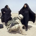 Una soldado americana cachea a dos mujeres en un punto de control de sureste iraquí