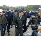 Varios policías detienen a un grupo de inmigrantes en un campamento, en Francia.