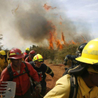 Bomberos huyen del fuego después de que más de 60 casas fuesen arrasadas por las llamas en La Cruz y Mariposas.