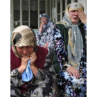 Dos mujeres lloran la pérdida de sus seres queridos.
