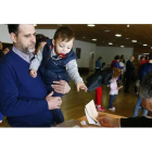 Un niño acompaña a su padre a votar en un colegio electoral de León