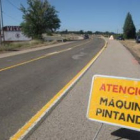 Un cartel advierte a los conductores de la presencia de máquinas trabajando al coronar el Alto de La