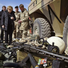 Angela Merkel observa varias piezas de armamento en su visita a Afganistán.