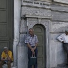 Pensionistas esperan para cobrar frente a un banco de Atenas (Grecia).
