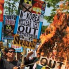 Activistas surcoreanos queman banderas y retratos del líder norcoreano Kim Jong-iI durante una prote