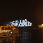 Dos barcos de rescate trabajan junto al 'Costa Concordia', totalmente ladeado, la pasada noche.