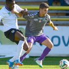 El culturalista Diego Peláez se lleva el balón ante la presión del jugador del Burgos CF Moke en un lance del encuentro disputado en El Plantío.