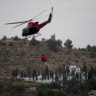 Un helicóptero sobrevuela una de las zonas arrasadas por las llamas, cerca de la Sierra de Espadán.