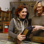 Raquel Jaén, directora del Museo de San Isidoro, y la restauradora de libros Ana Jessen, observan uno de los códices de la biblioteca de la colegiata.