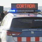 Un vehiculo de los Mossos dEsquadra corta una carretera por un accidente de tráfico.