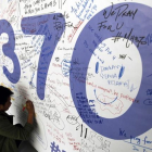 AUS01. KUALA LUMPUR (MALASIA), 30/07/2015.- Fotografía de archivo del 13 de marzo de 2014 de un hombre escribiendo mensajes en honor a las víctimas del vuelo MH370 de Malaysia Airlines en el aeropuerto internacional de Kuala Lumpur (Malasia).