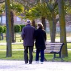 En la fotografía, una pareja de casados pasea por un parque