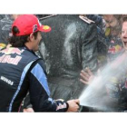 Mark Webber rocía a sus mecánicos con champán tras adjudicarse el GP de Mónaco.
