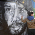 Un niño toca el rostro de Camarón, en el grafiti homenaje al pueblo gitano bajo la bolera de San Marcos. JESÚS F. SALVADORES