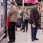 Un grupo de personas comprando en un supermercado.