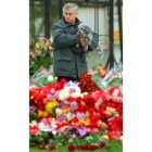 Un hombre observa las flores que recuerdan a las víctimas del teatro