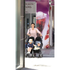 Una mujer pasea una pareja de bebés en León. RAMIRO