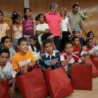 Los niños con sus regalos, posan  para la foto junto al alcalde, la concejala y el delegado saharaui