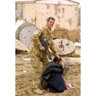 Un soldado norteamericano apunta a uno de los prisioneros en Basra, Irak