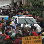 Migrantes hondureños hacen fila en un control policial donde se les verifica sus antecedentes penales y si tienen alguna orden de captura.
