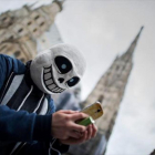 Tras una máscara, un usuario de Pokémon Go juega con la aplicación en las calles de Viena.
