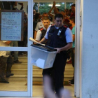 Un mosso se lleva una urna de un colegio durante el referéndum del 1-O.