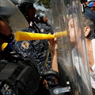 Una manifestantes de la oposición se encara con los antidisturbios en la protesta de este sábado en Caracas.