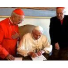 Benedicto XVI firma unos papeles en blanco en la mesa del despacho de Juan Pablo II