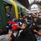 Los cientos de inmigrantes que han esperado durante dos días la reapertura de la estación de Keleti suben masivamente al primer tren.