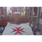 Varias vecinas de Valdavida sostienen el pendón blanco de la Orden de Malta que han podido reconstruir con una subvención del ILC.