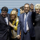 Daniel Scioli, segundo por la derecha, saluda junto a su esposa Karina Rabolini y a su candidato a vicepresidente Carlos Zannini en el acto de cierre de campaña en Buenos Aires.