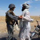 Un policía afgano cachea a un ciudadano en un punto de control en la ciudad de Lashkar Gah tras la fin del proceso de paz.