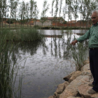 Belarmino Fernández señala el agua podrida de la laguna situada junto al casco urbano.