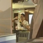 Captura del vídeo en el que se ve a la azafata de Emirates rellenando una botella de champán con restos de copas usadas.