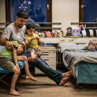 Un refugiado sirio explica cuentos a sus hijos antes de dormir, en un centro de acogida en Prenzlauer Berg (Alemania).