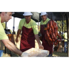 Varios voluntarios preparan el chorizo al vino prieto picudo en una edición pasada de la fiesta de Valdevimbre.