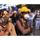 Una manifestante con máscara antigas ruega a los antidisturbios que no usen gas lacrimógeno, el sábado en la calle Istiklal de Estambul.
