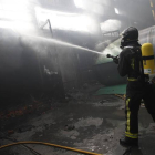 Un bombero apaga un incendio en una nave en Villamañán