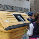 Un niño arroja un envase al contenedor amarillo con ayuda de su madre, ayer en la capital de la provincia.