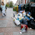 Los primeros contenedores desbordados ayer en la calle Suero de Quiñones como consecuencia del cuarto día de huelga