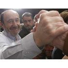 Rubalcaba recibe la felicitación de un militante después de presentar formalmente su candidatura a suceder a Zapatero en el PSOE.