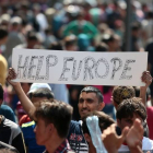Un inmigrante se manifiesta este jueves en Budapest con una pancarta en la que se lee "Ayúdanos Europa".