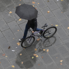 Un viandante se protege de la lluvia. JAVIER CEBOLLADA