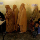 Mujeres ataviadas con burkas votan en un colegio electoral en Peshawar.