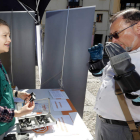 Una persona prueba a leer y escribir con unas gafas que simulan los síntomas con el peso y el temblor en las manos. MARCIANO